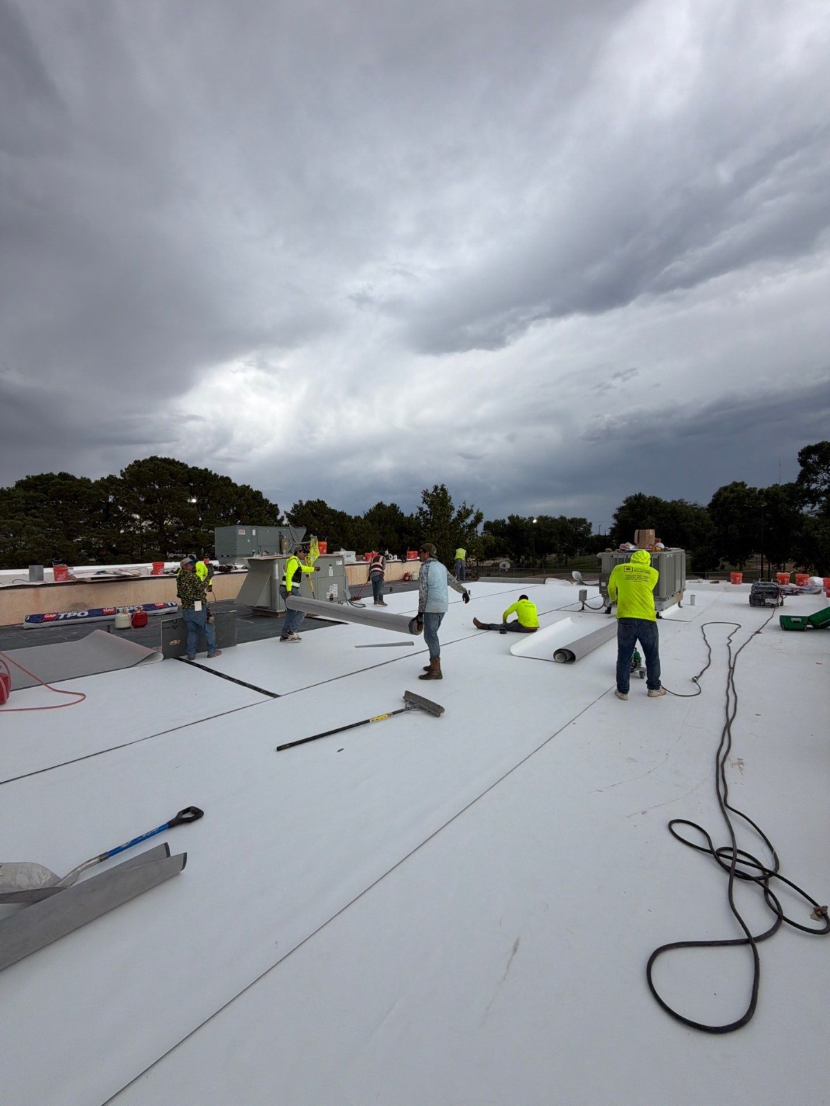 Crew installing the white TPO membrane on the Copper Rawlings Senior Center roof