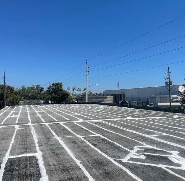 Commercial flat roof with seam repairs and protective coating applied for leak prevention.