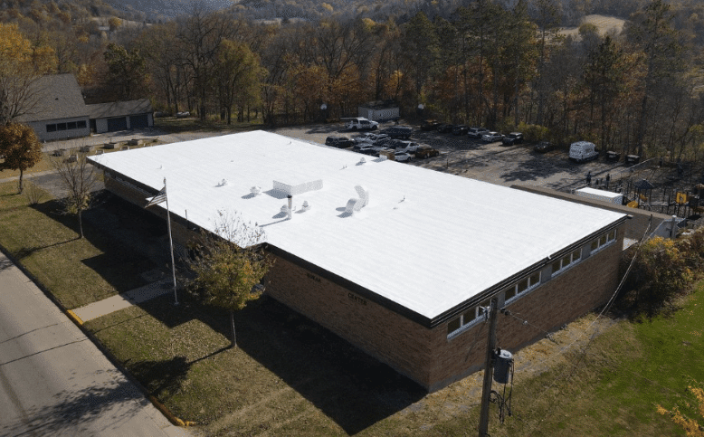 Commercial building with a new white reflective flat roof coating to improve energy efficiency and durability.