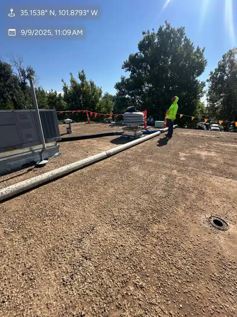 Workers installing roofing materials outdoors.