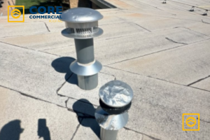 An aging modified bitumen commercial roof showing surface cracking and severe hail damage to a metal roof vent cap in West Texas.